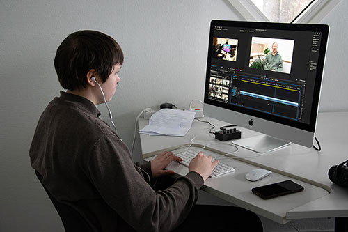 Kuvassa opiskelija editoi videomateriaalia tietokonella Adobe Premiere Pro:lla